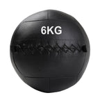 A black, double-stitched, textured wall ball with the weight '6KG' printed on it.
