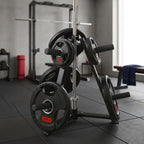 A black and silver weight stack rack loaded with black 20kg weight plates, shown in a gym setting with a squat rack and window in the background.