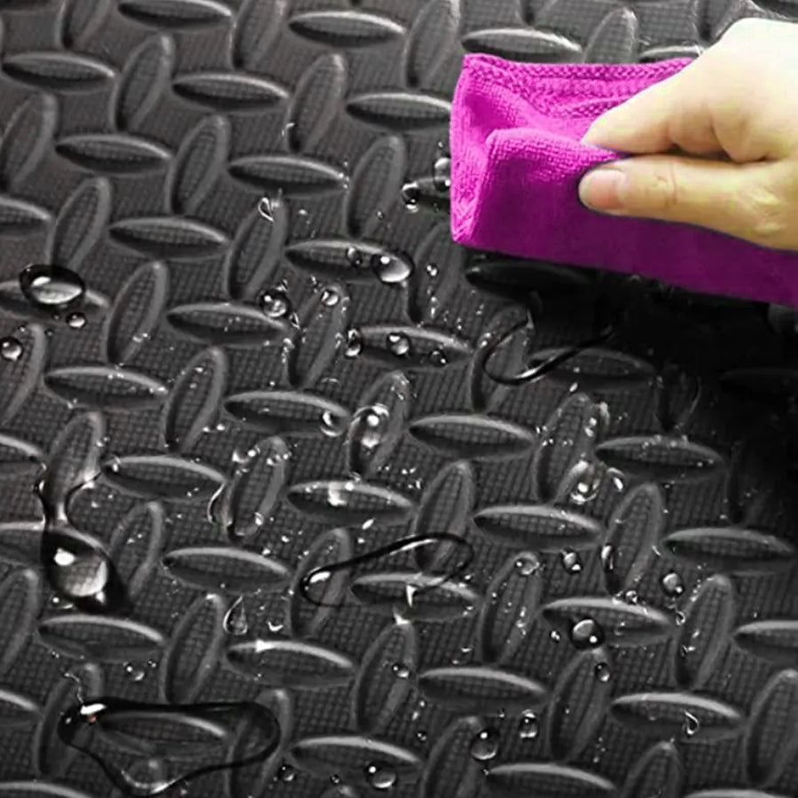 Person cleaning a textured black surface with a purple cloth