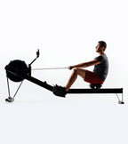 Person using a rowing machine on a white background