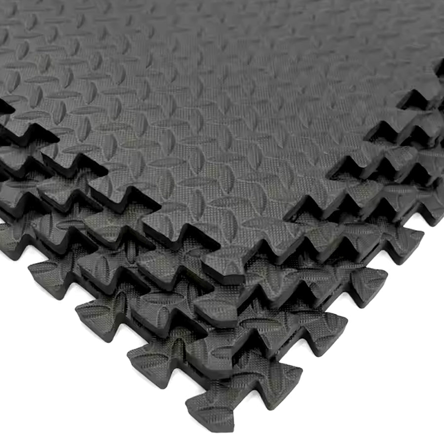 Interlocking black EVA foam tiles with a puzzle-like design, showing shock absorption and non-slip surface texture.