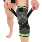 Person wearing a black and green knee brace on a white background