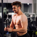 Man exercising with a rope attachment in a gym setting