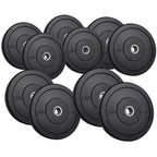 Set of black weight plates with varying weights on a white background
