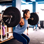 Woman lifting a barbell in a gym setting