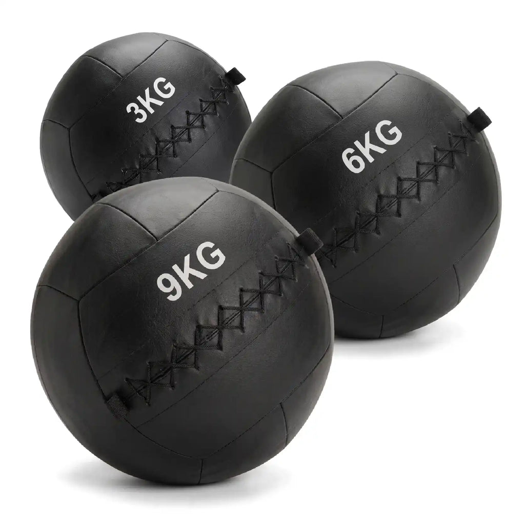 Three black rubber medicine balls in 3KG, 6KG, and 9KG sizes, arranged on a clean white background.