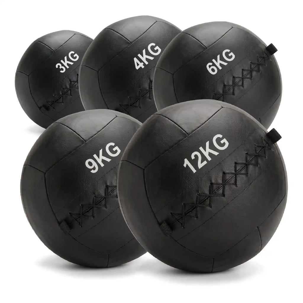 Five black rubber medicine balls in different weights (3KG, 4KG, 6KG, 9KG, 12KG) arranged on a white background.