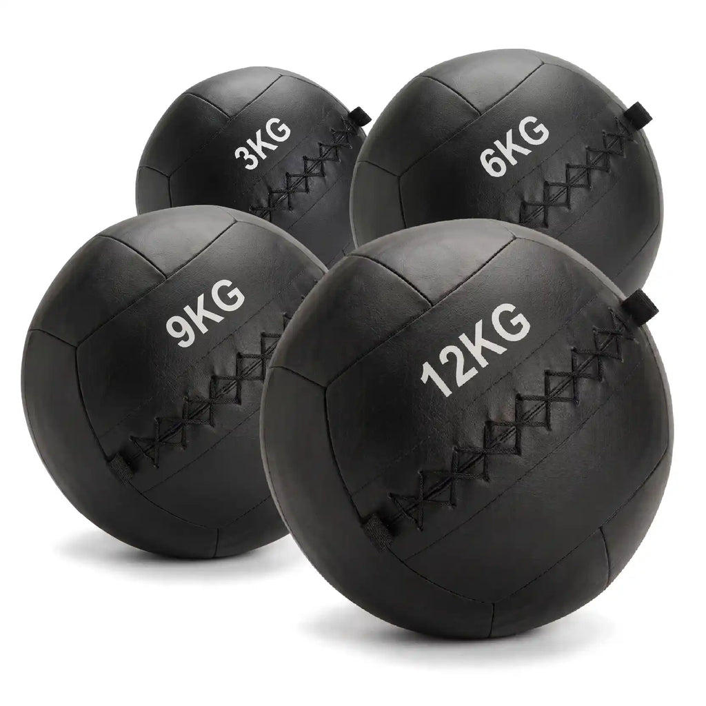 Four black rubber medicine balls in sizes 3KG, 6KG, 9KG, and 12KG, arranged on a white background.