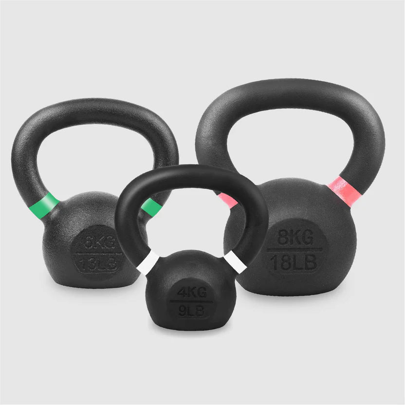 Three black kettlebells of different weights on a light gray background