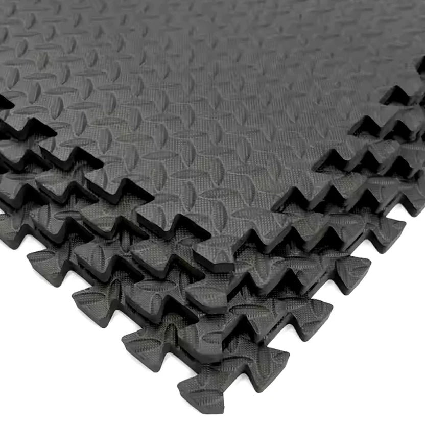 Stack of black interlocking foam mats with textured surface